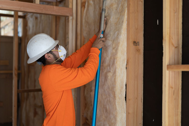 technician installing batt insulation